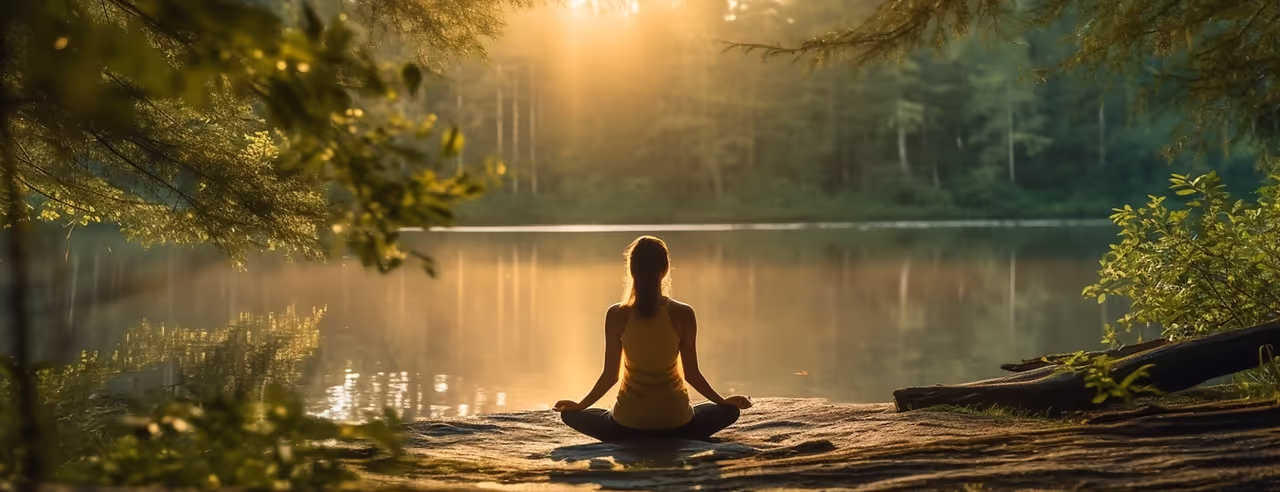 Frau meditiert am See
