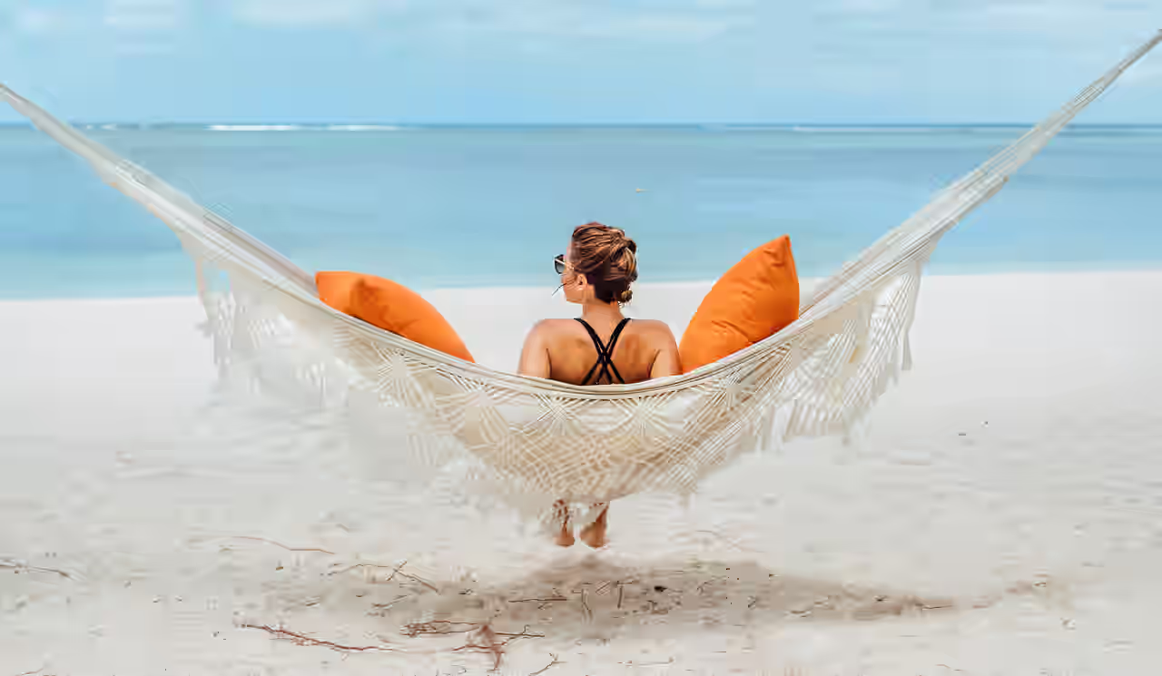 Eine Frau sitzt auf einer Hängematte am Strand auf Mauritius
