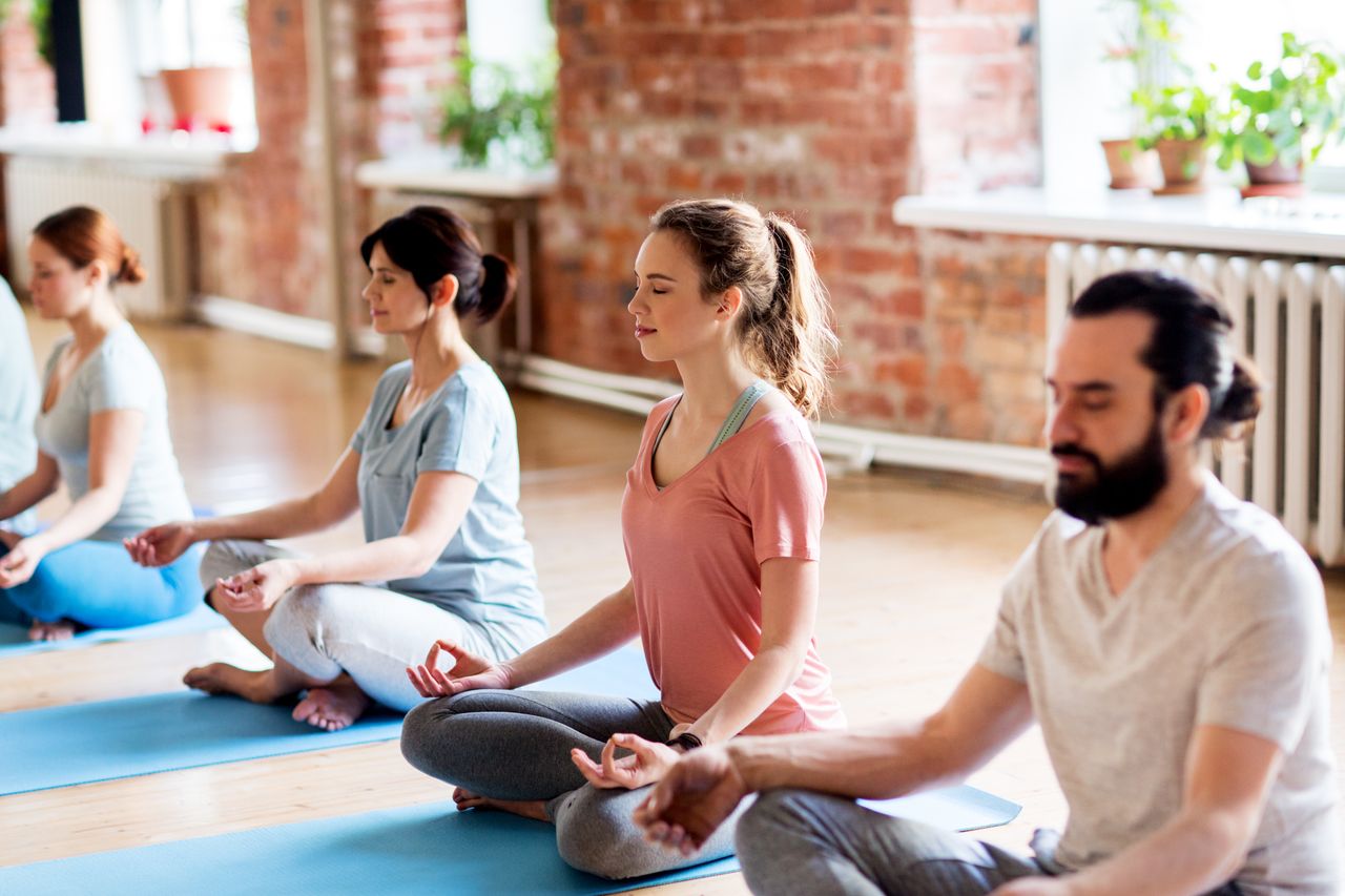 Mehrere Personen meditieren im Ashram