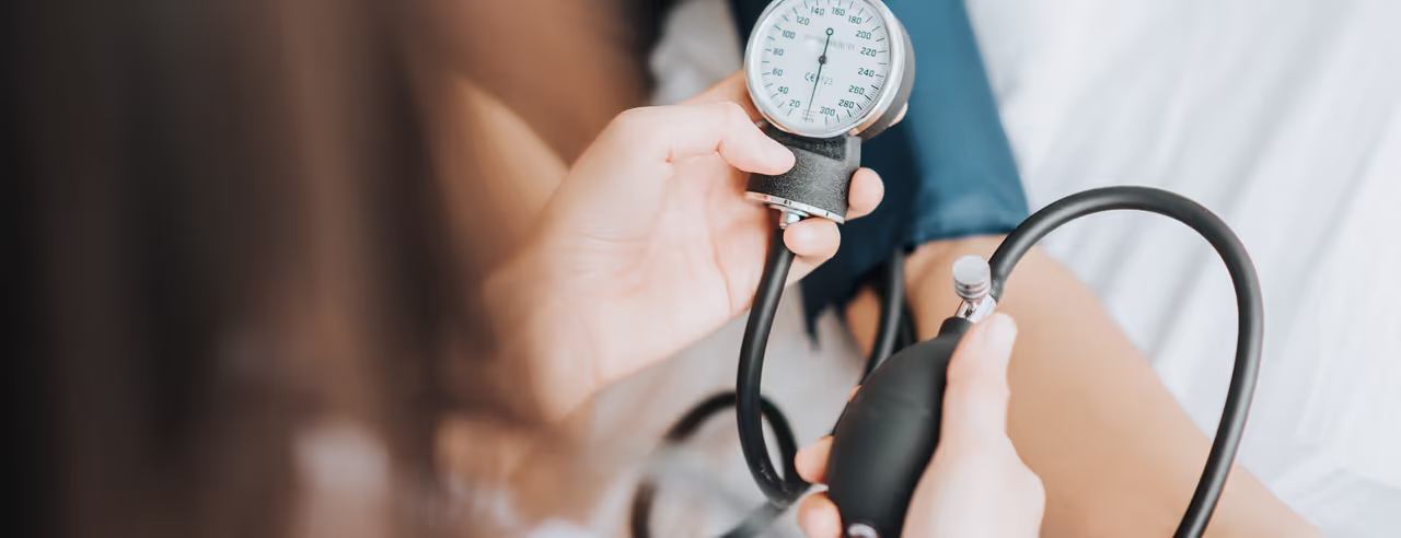 A woman uses a blood pressure monitor
