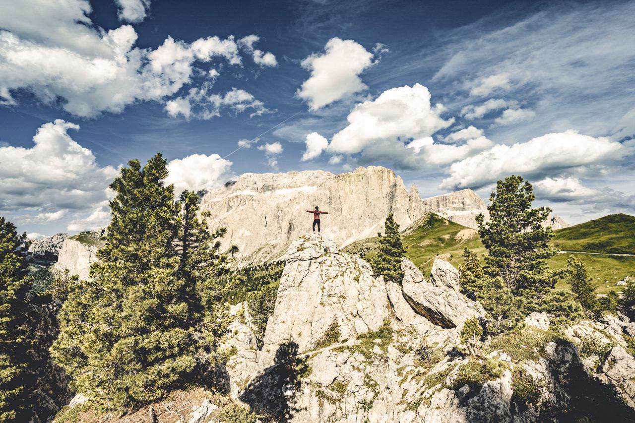 Eine Frau übt Yoga auf einem Berggipfel in ihrem Yoga Urlaub in Tirol