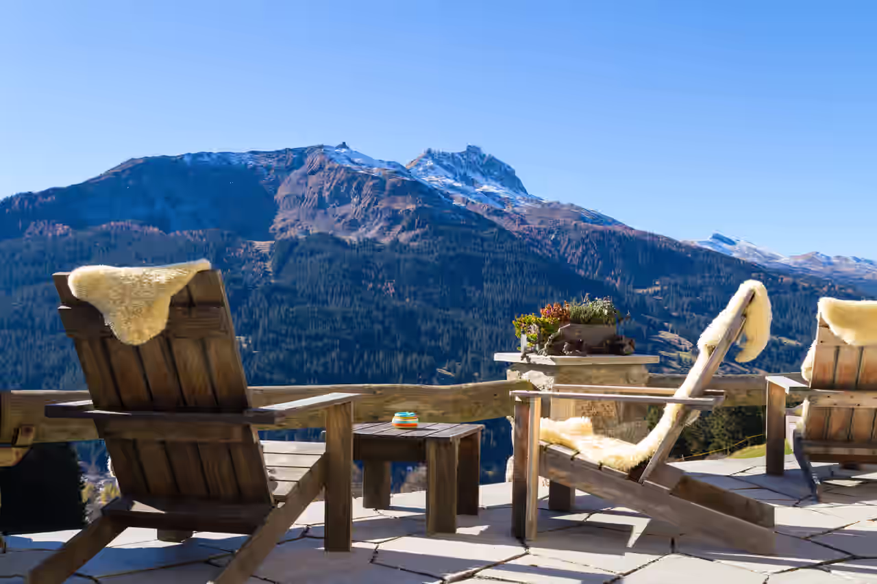 Stühle auf einer Chalet-Terasse mit Bergblick