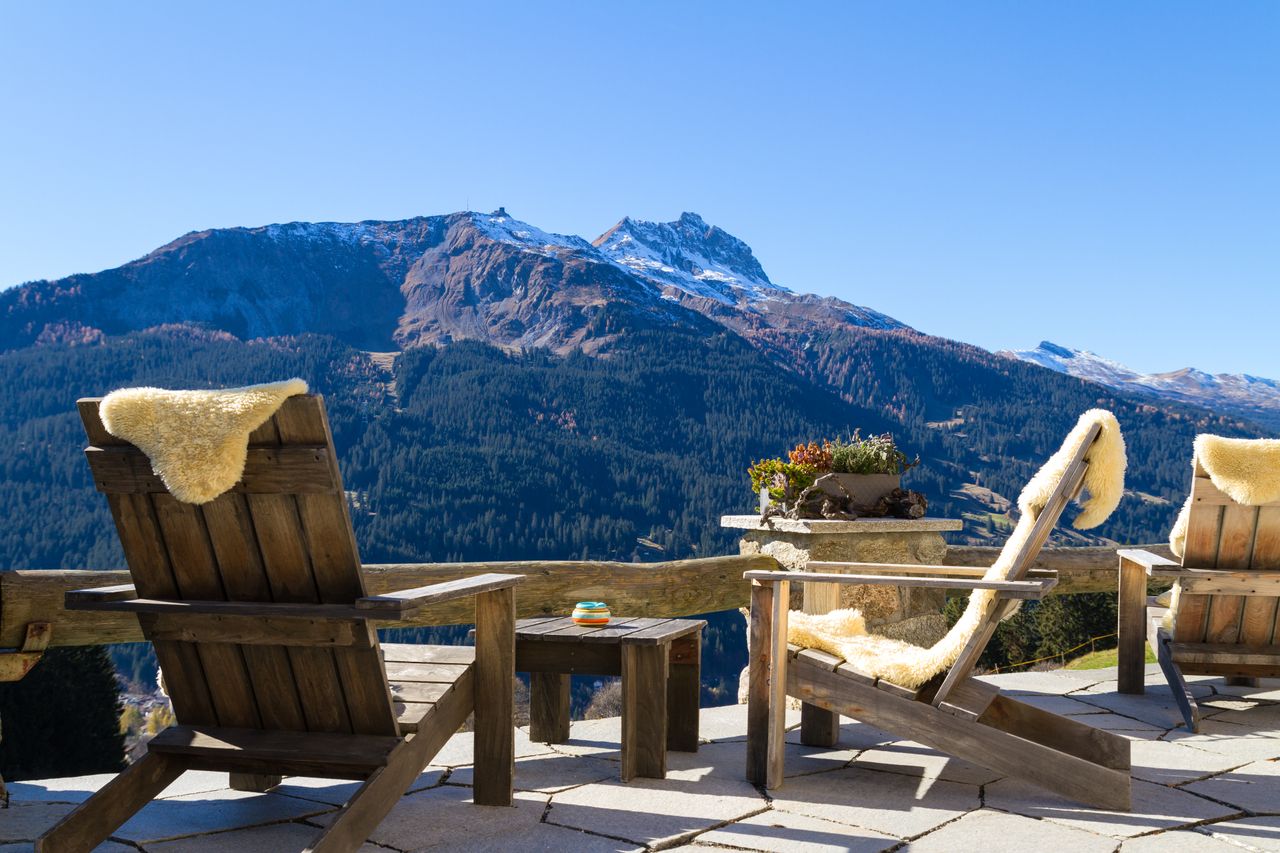 Stühle auf einer Chalet-Terasse mit Bergblick