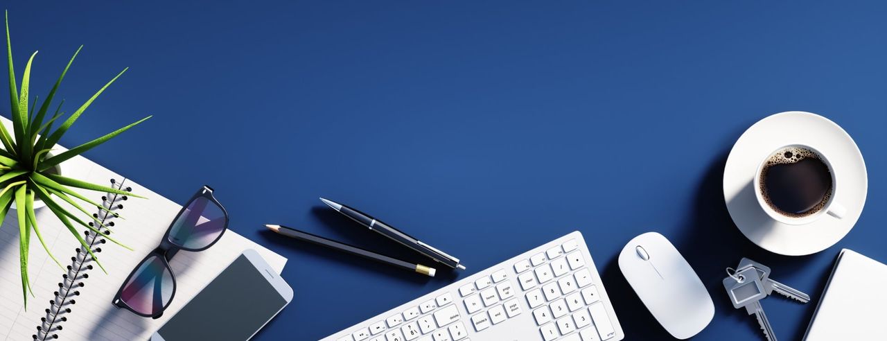 Schreibtischszene mit Stift, Bleistift und Tastatur auf blauem Hintergrund