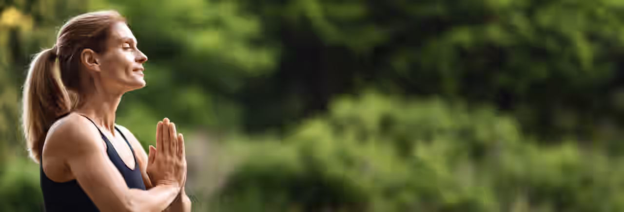 Eine Frau meditiert im Wald