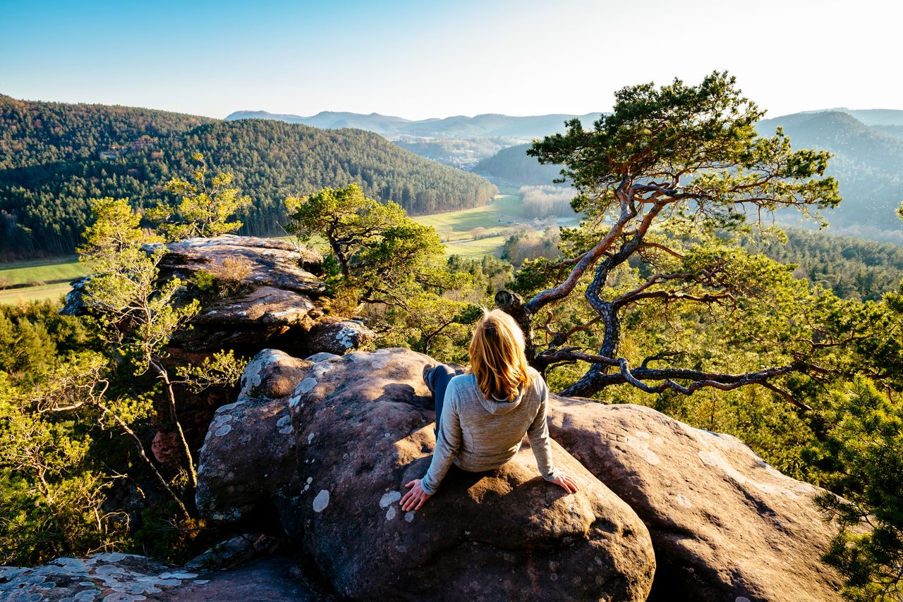 Frau auf Felsen mit Blick auf Landschaft in Rheinland-Pfalz