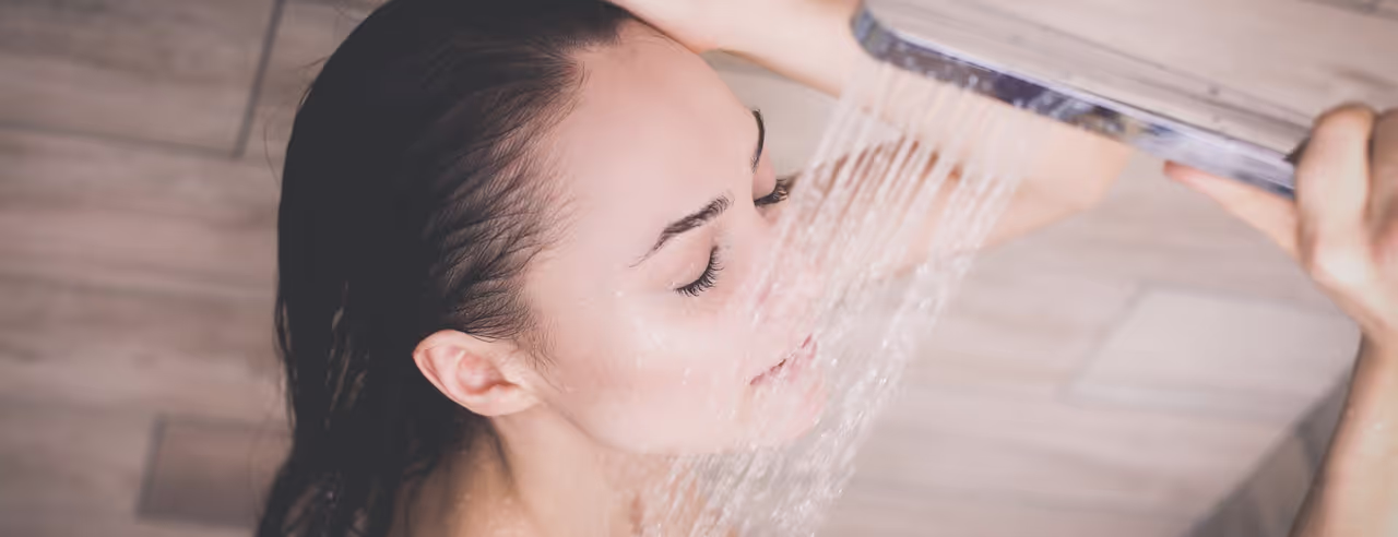 Frau unter einem Duschkopf