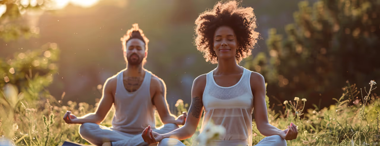 Deux personnes assises sur une pelouse méditent ensemble
