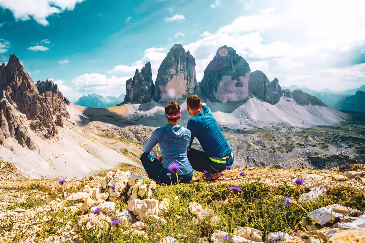 Zwei Personen in Sportkleidung bewundern die Berggipfel der Dolomiten in Südtirol