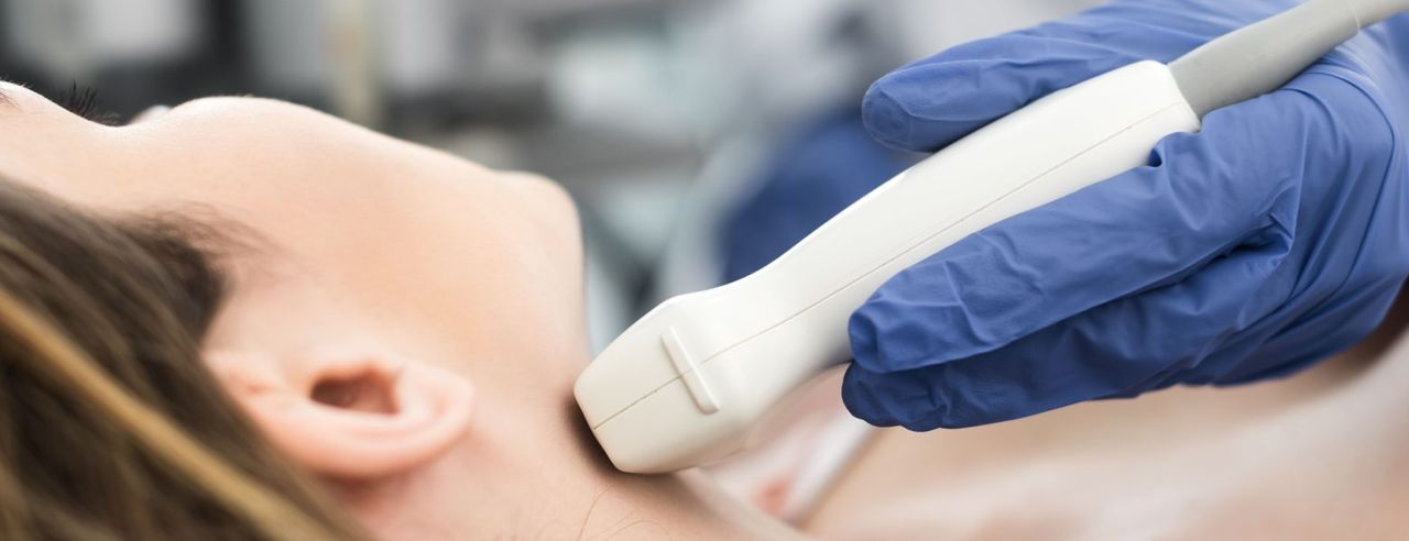 Bei einer Frau wird die Schilddrüse untersucht