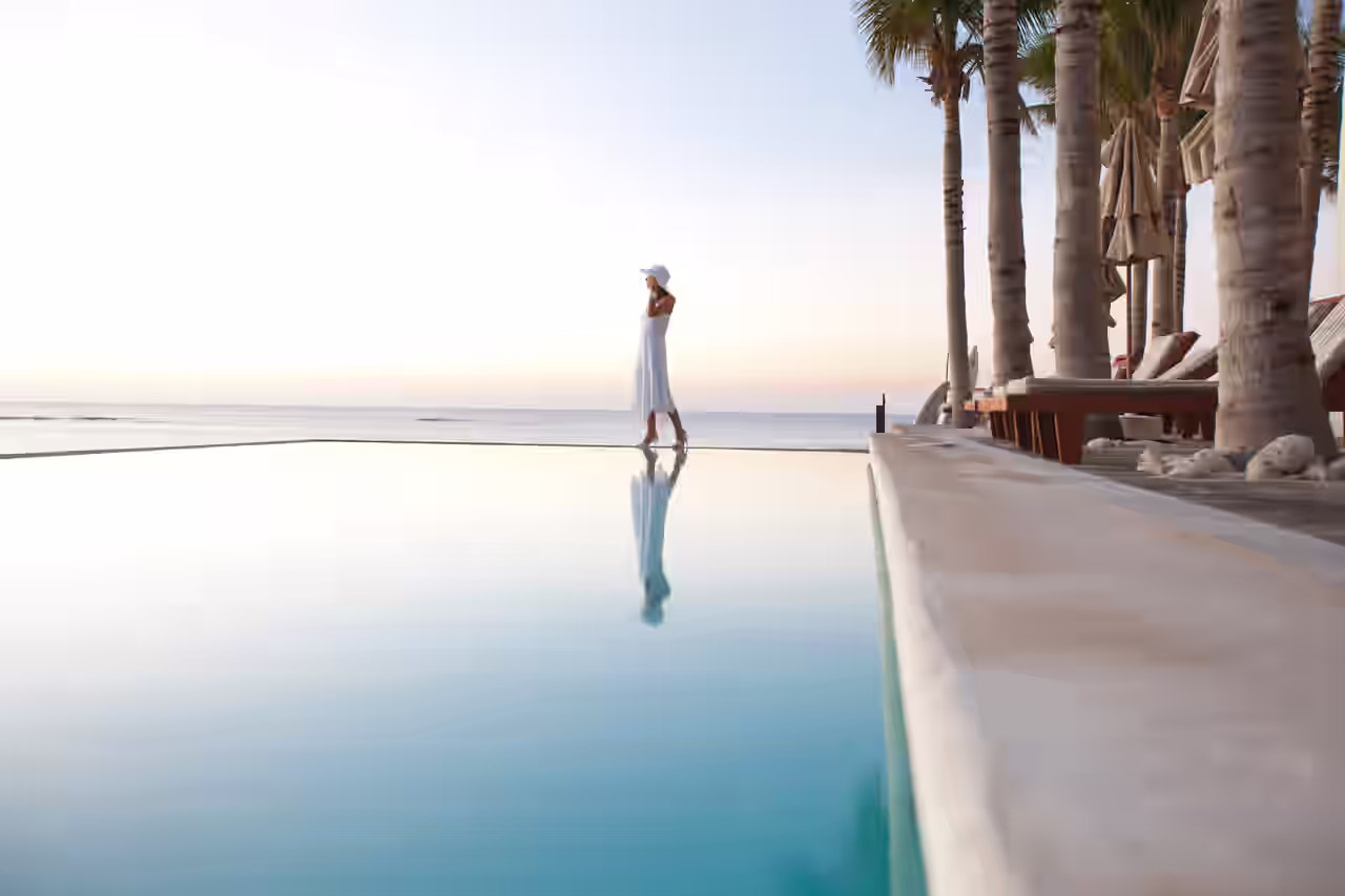 Een vrouw ligt bij het zwembad van haar luxe hotel