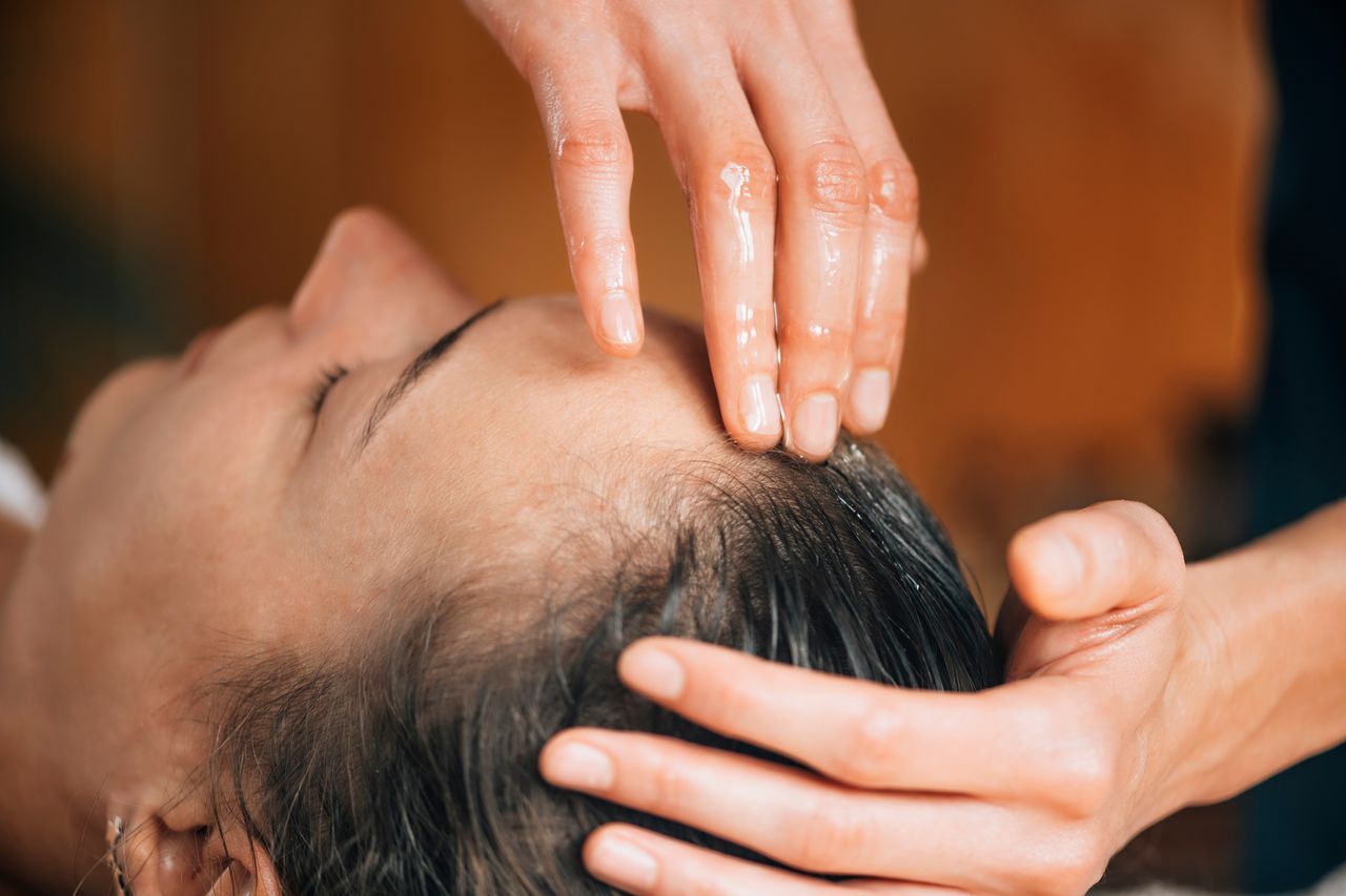 Frau bekommt eine Marma-Massage des Vitalpunktes am Kopf