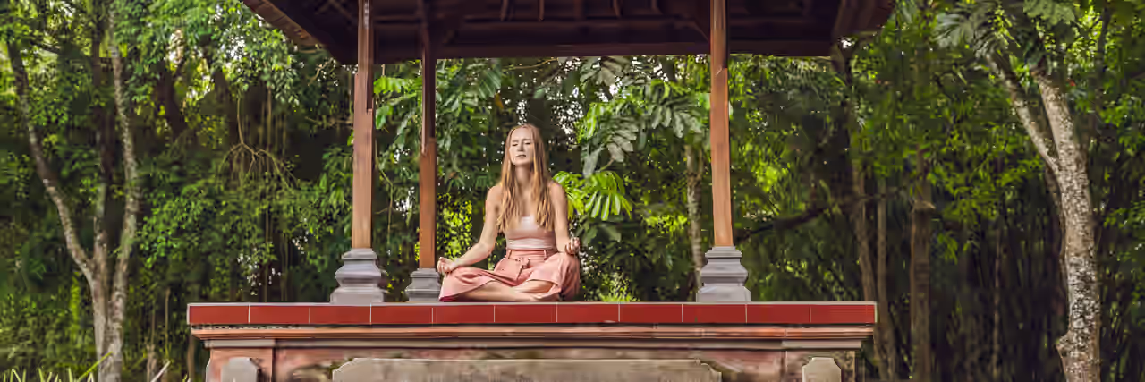 Eine Frau meditiert an einem Schrein in Thailand