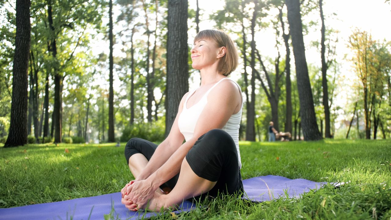 Frau in Yoga Pose im Park