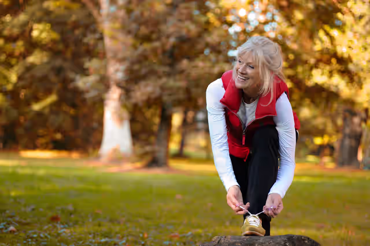 Ältere Frau bindet sich den Schuh für Outdooraktivität im Gesundheitsurlaub