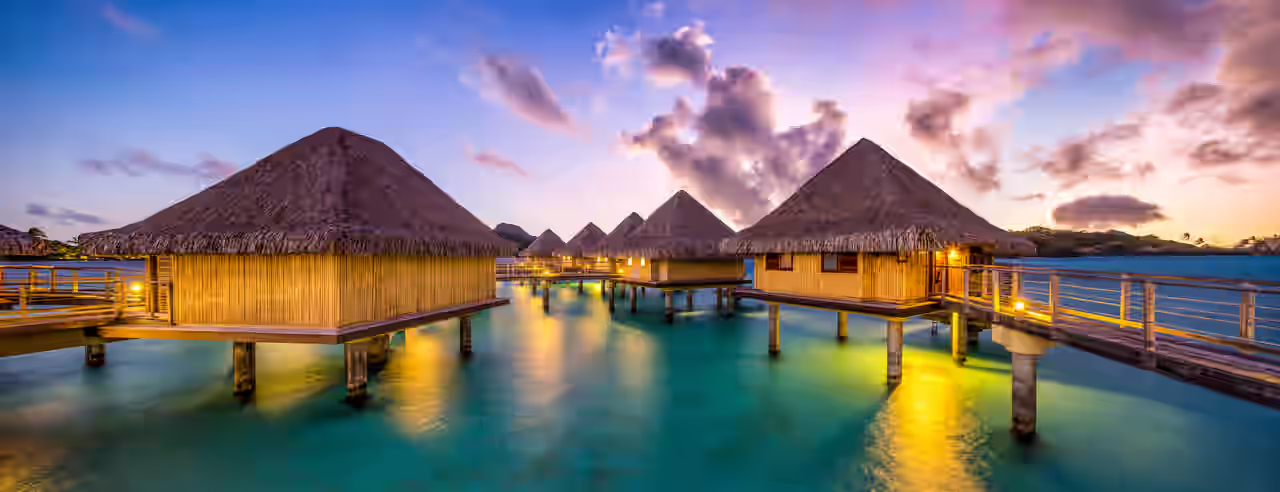Bungalows im Meer bei Sonnenuntergang