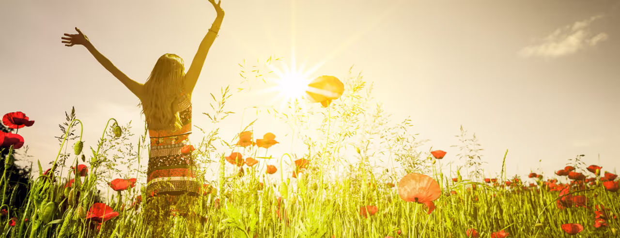 Frau streckt sich im Mohnfeld