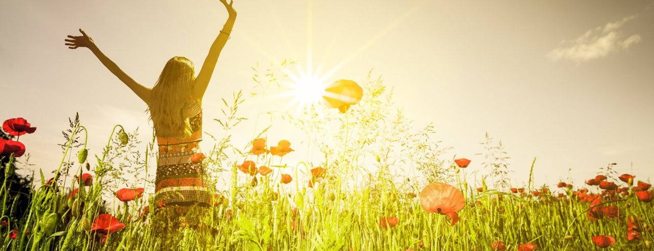 Frau streckt sich im Mohnfeld