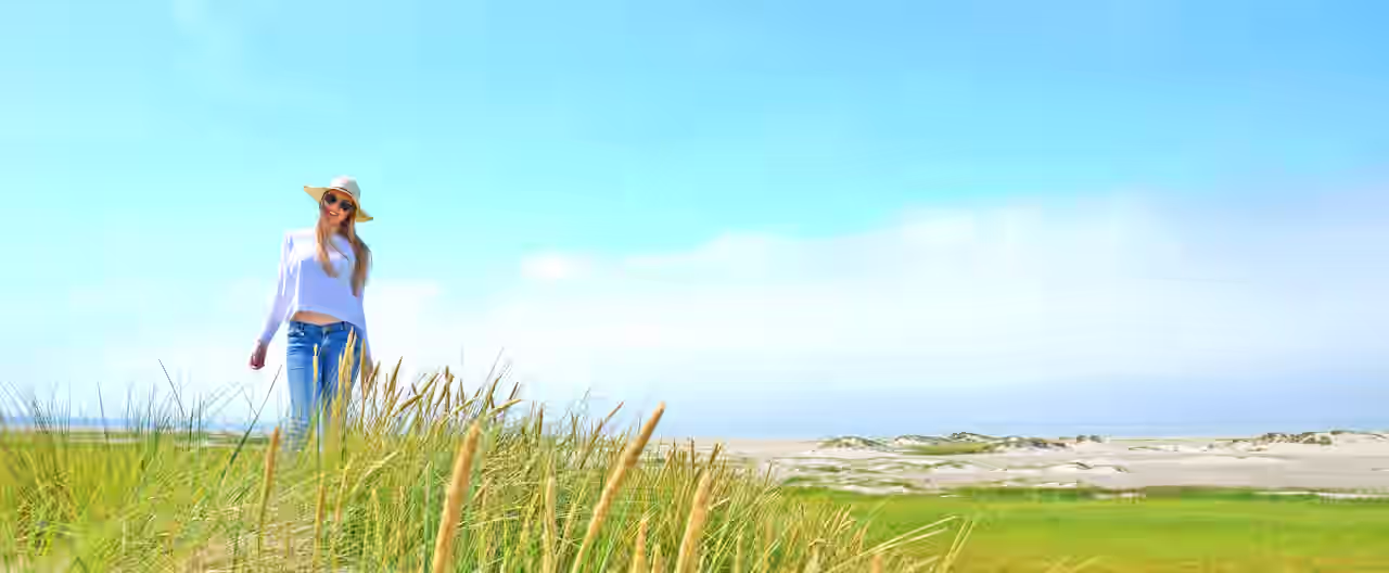 Eine Frau spaziert am Nordsee-Strand