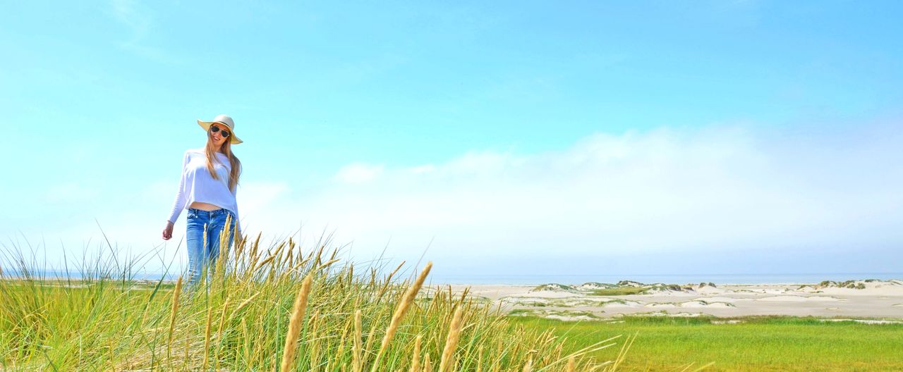 Eine Frau spaziert am Nordsee-Strand