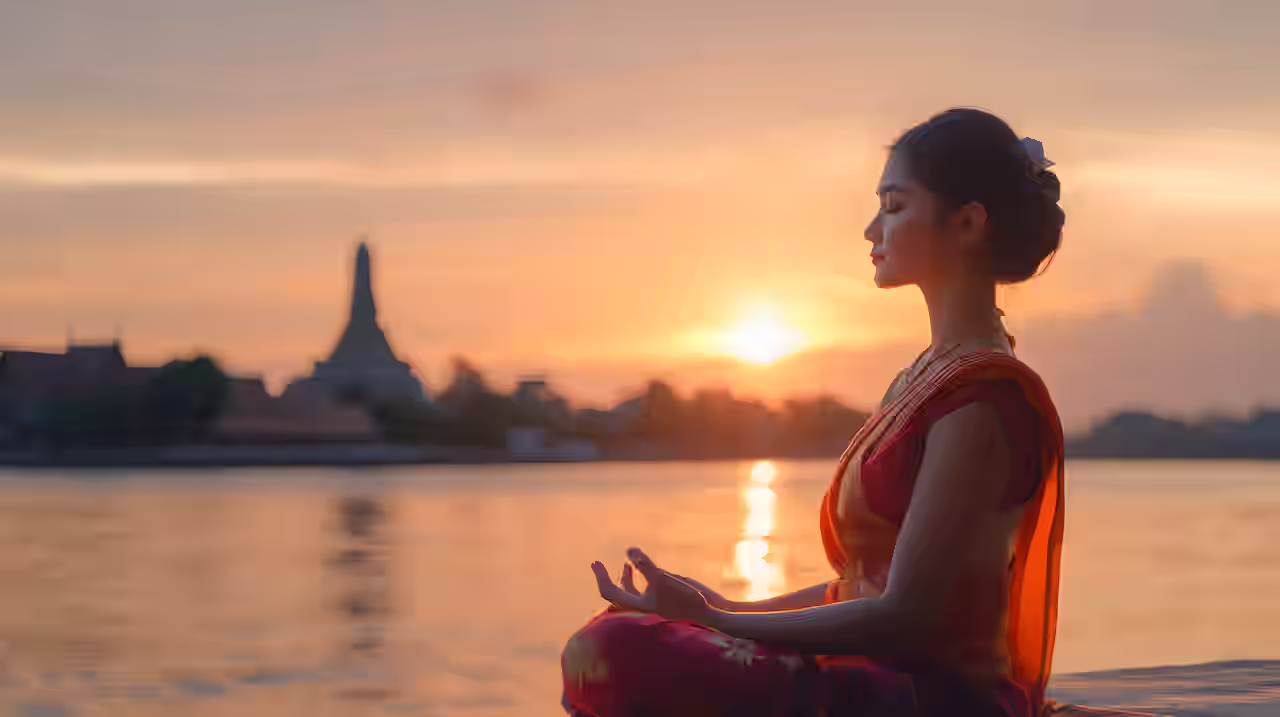 Meditierende Frau vor Sehenswürdigkeit in Thailand