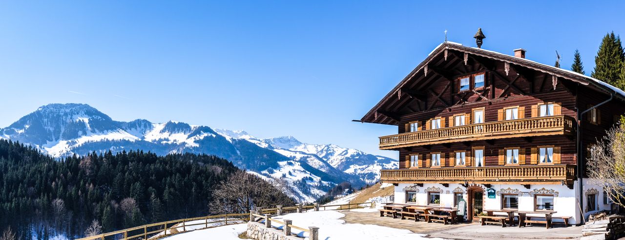 Ein Naturhotel inmitten der Berge Österreichs und die schneebedeckten Gipfel im Hintergrund