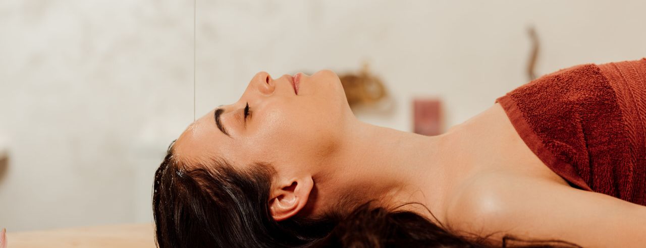 Eine Frau beim Shirodhara