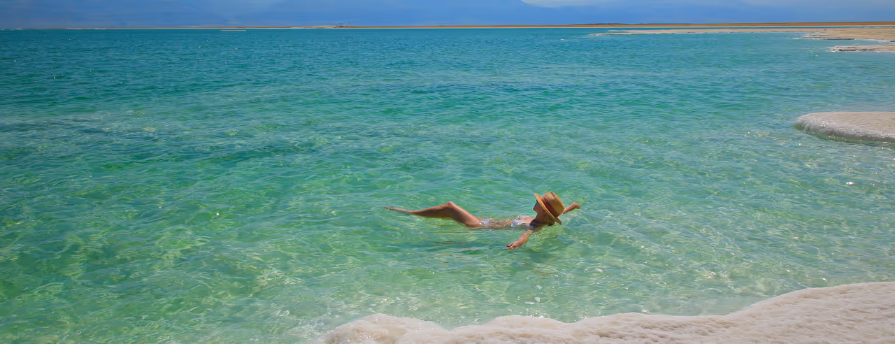 Eine Frau schwebt im Wasser des Toten Meeres