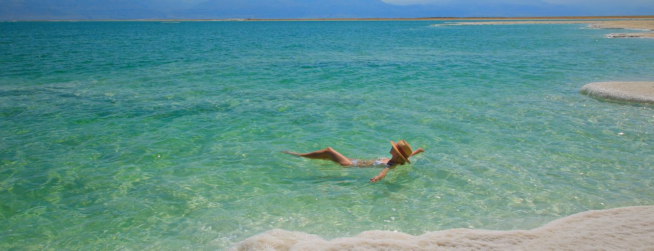 Eine Frau schwebt im Wasser des Toten Meeres