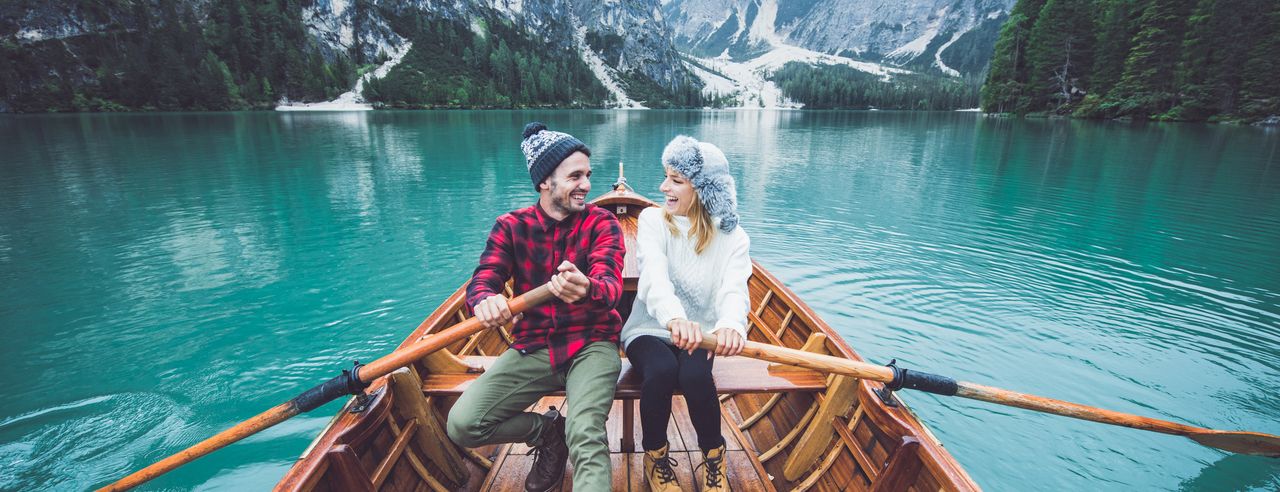 Ein Paar auf einem Bergsee in den Alpen während ihrer Hochzeitsreise