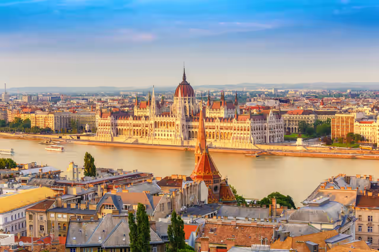 Blick auf das Parlament und die Donau in Budapest bei abendlichem Sonnenlicht