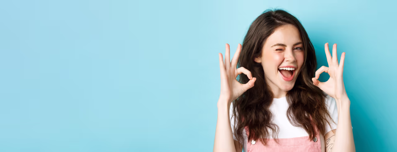 Eine Frau macht das Ok-Zeichen und lächelt, weil sie durch Akupunktur abgenommen hat