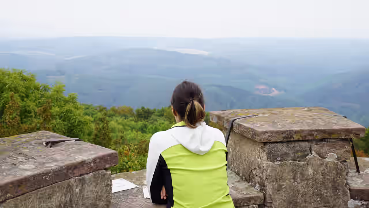 Eine Frau auf einem Aussichtspunkt beim Wandern im Spessart