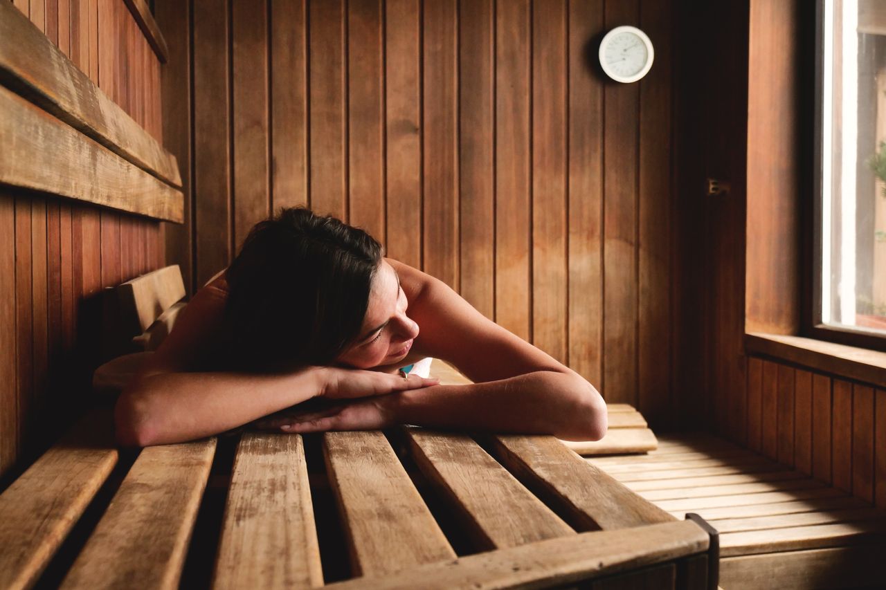 Eine Frau in der Sauna genießt ihren Wellnessurlaub im Erzgebirge