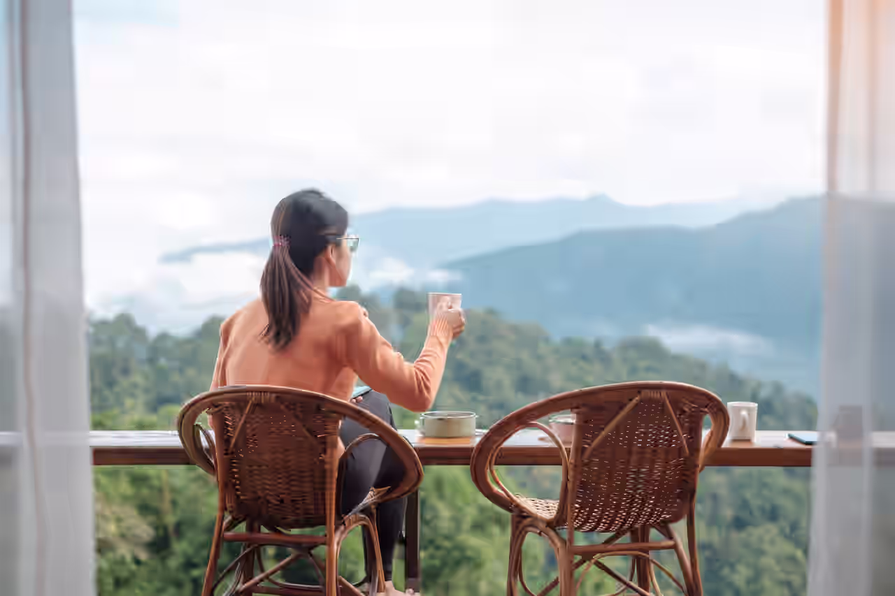 Eine Frau verzerrt eine Speise mit einem warmen Getränk und Bergblick