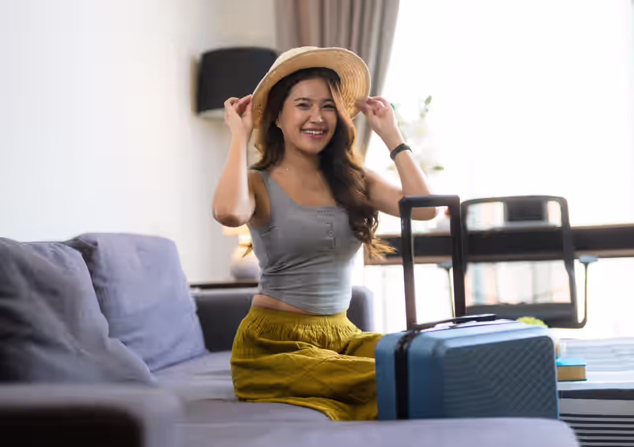 Eine Frau mit Koffer sitzt im Hotelzimmer