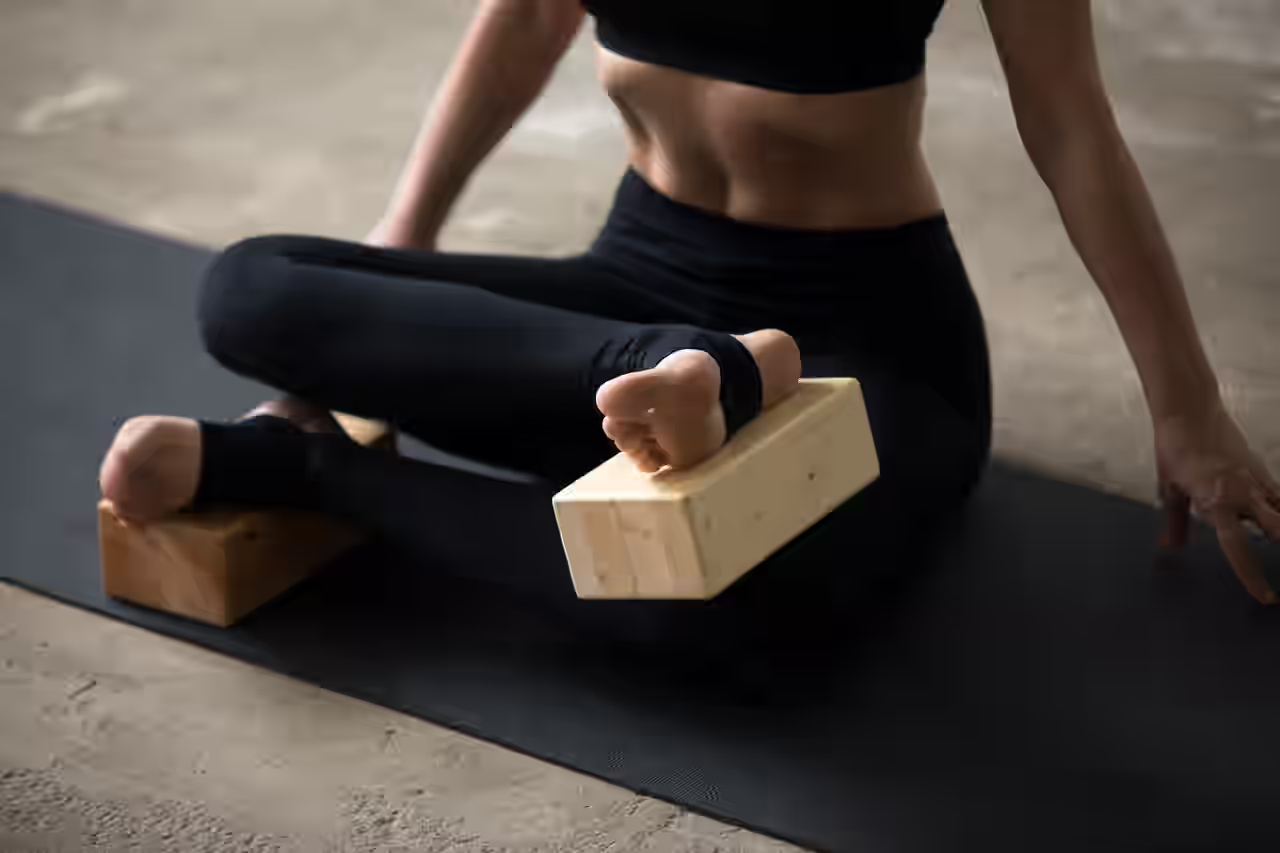 Eine übt Iyengar Yoga mit Klötzen an den Füßen