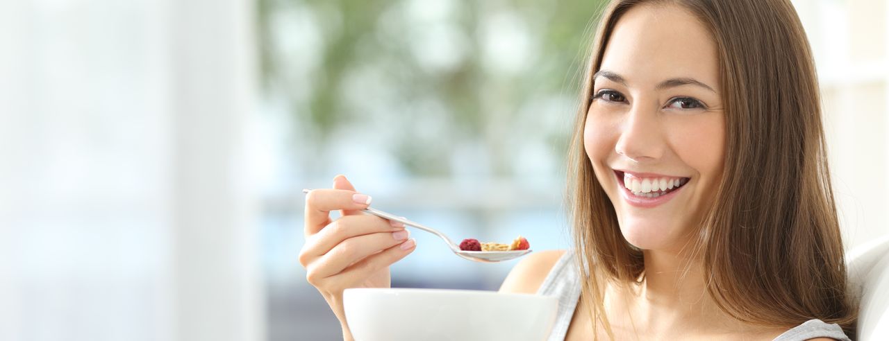 Mujer feliz comiendo muesli