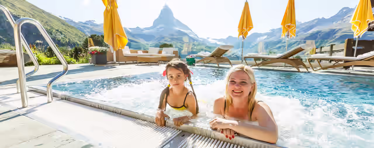 Mutter und Tochter im Außenpool mit Bergpanorama