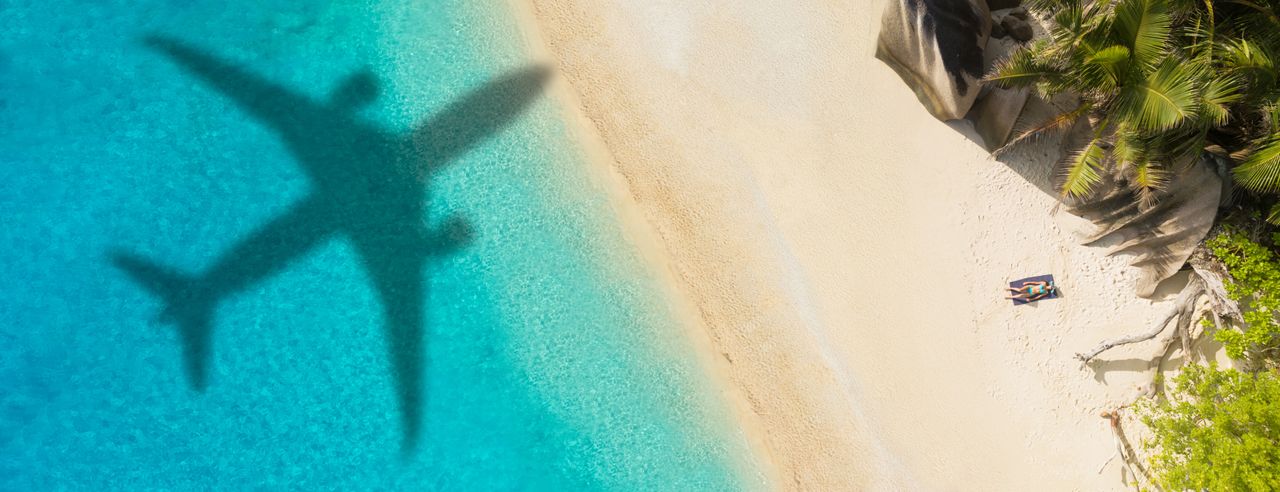 Der Schatten eines Flugzeugs am Tropenstrand