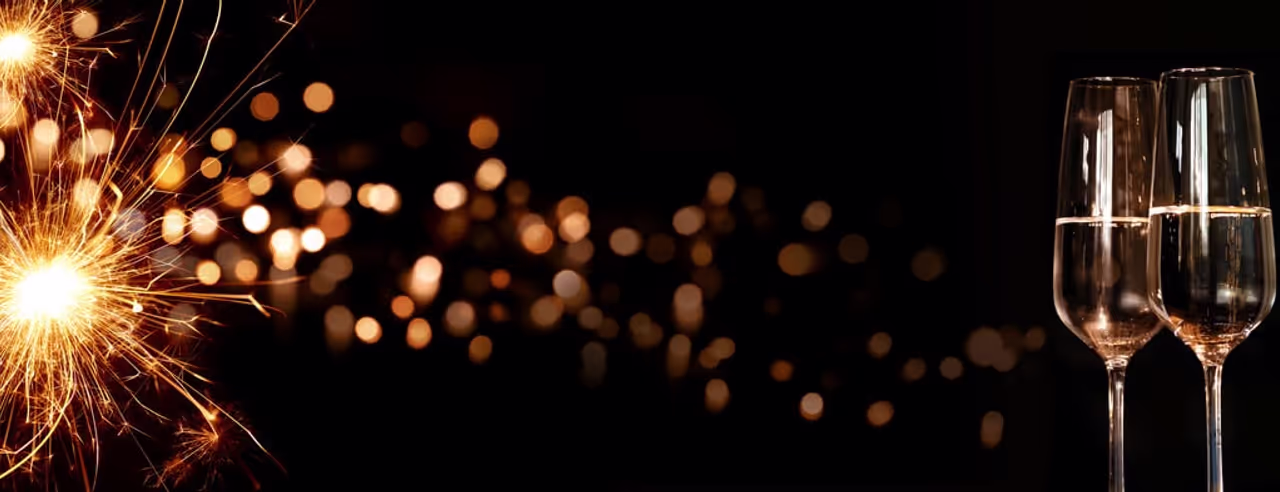 Silvesterfeier mit Wunderkerze und Sektgläsern