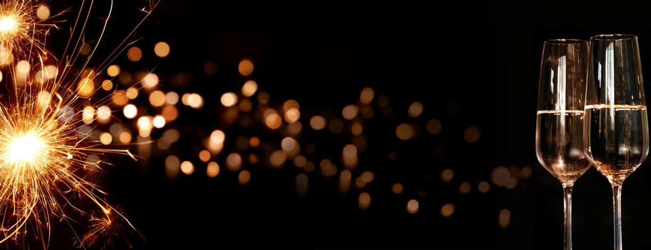 Silvesterfeier mit Wunderkerze und Sektgläsern