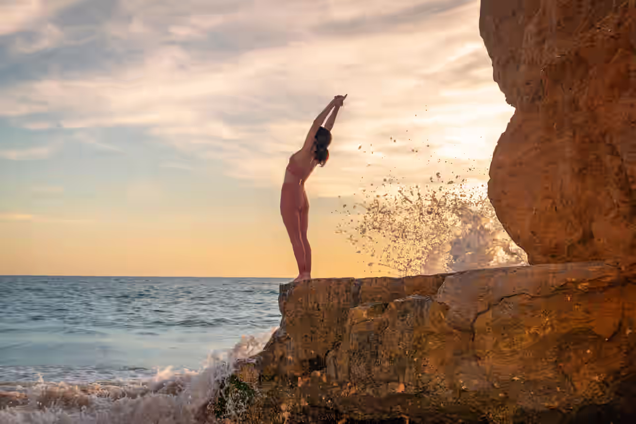 Frau macht an Felsklippe am Meer Yoga