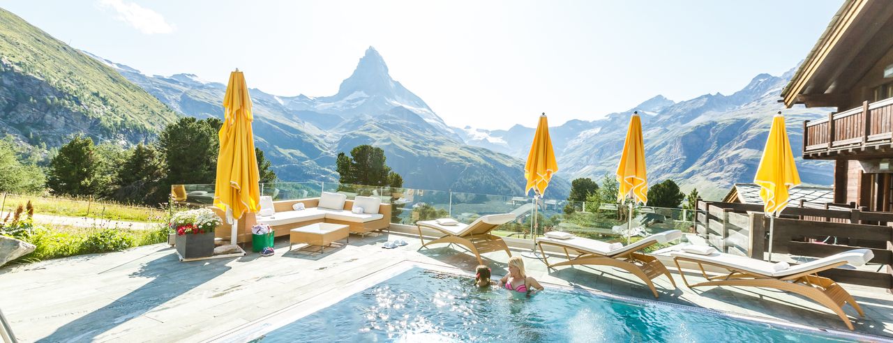 Women in the pool of a luxury hotel in Switzerland, with a view of the Matterhorn