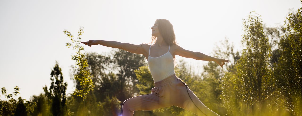 Frau macht Yoga in grüner Natur