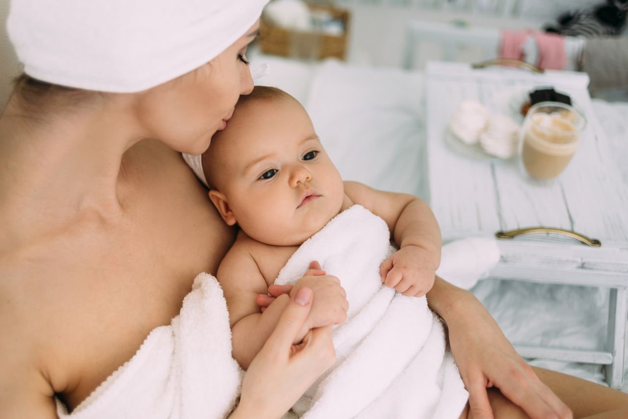 Mutter und Baby in Handtücher gehüllt