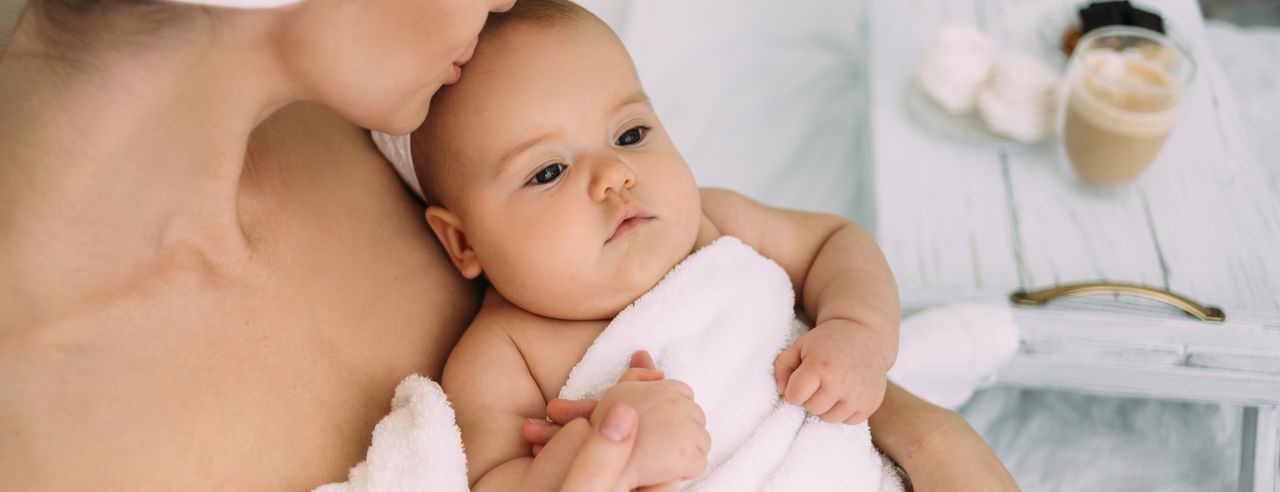 Mutter und Baby in Handtücher gehüllt