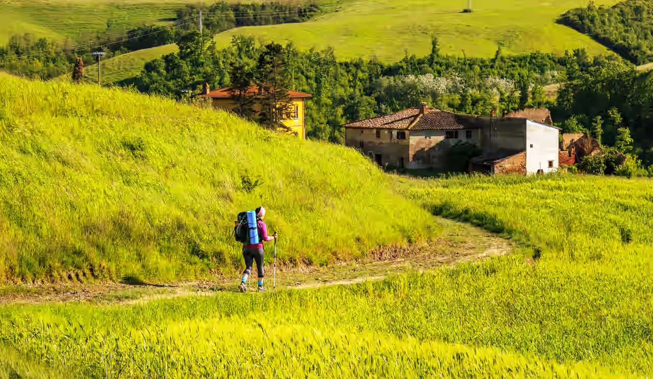 Wanderin, die über die Hügel der Toskana läuft