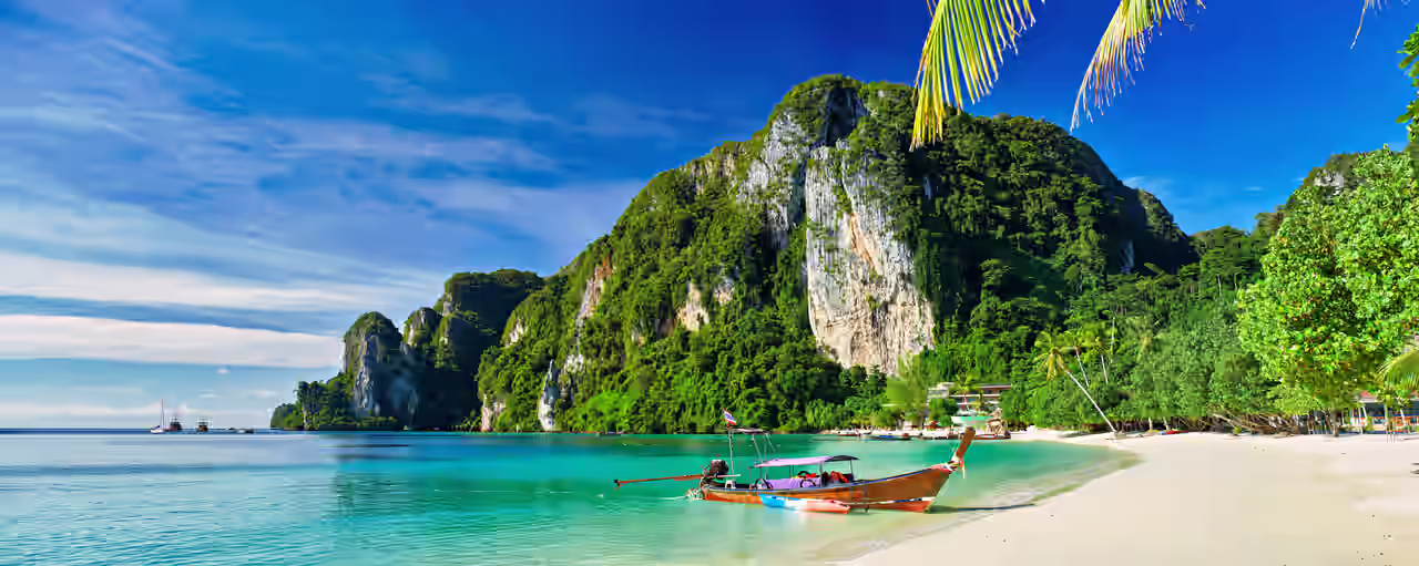 Bucht in Thailand mit Meer, Strand und Bergen sowie kleinem Boot