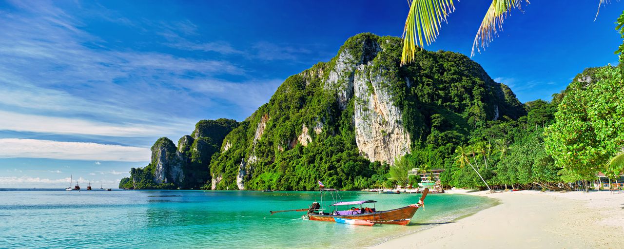 Bucht in Thailand mit Meer, Strand und Bergen sowie kleinem Boot